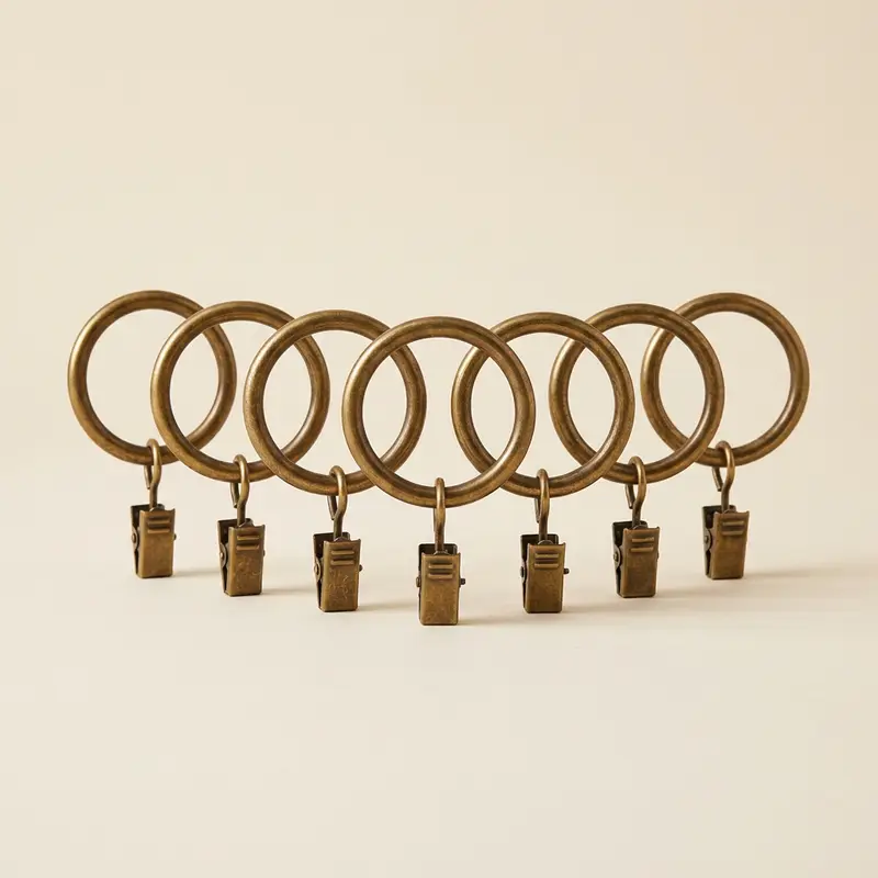 Calder curtain rings, set of 7 in Aged brass